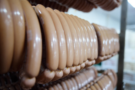 mouthwatering smoked sausages on the background of a meat factory or butcher shopの写真素材