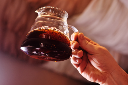 glass heat-resistant kettle for brewing coffee close-up against the background of a coffee houseの写真素材