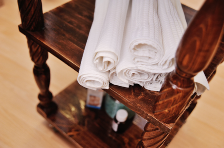 white towels on a beautiful wooden shelf against the backdrop of a beauty salon or hotel roomの写真素材