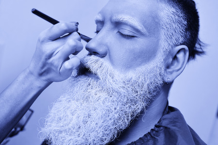make-up artist paints a mans beard, mustache and eyebrows in white or gray-haired colorの写真素材