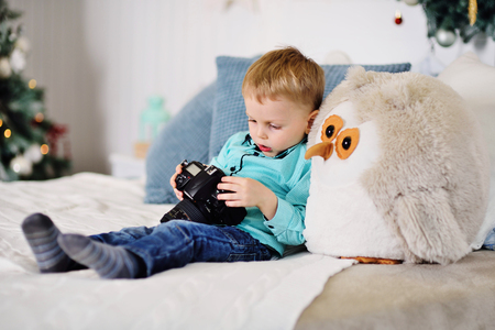 little baby boy with a SLR camera on the background of a Christmas decorの写真素材