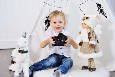 little baby boy with a SLR camera on the background of a Christmas decorの写真素材