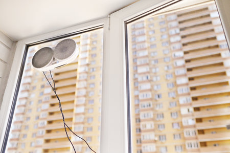 window cleaner robot cleans dirt on a window pane against the background of a multi-storey building...