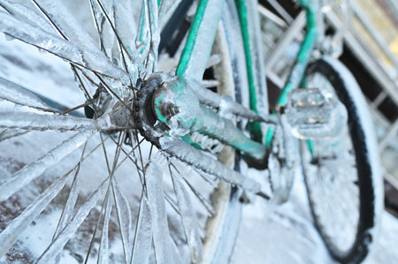 green retro bike in ice on a background of snow in winter in a severe frost.