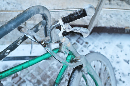 green retro bike in ice on a background of snow in winter in a severe frost.の写真素材