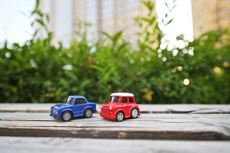 two toy cars against the backdrop of a multi-storey new building and greenery. Real estate, residential complex, new, parking.の写真素材
