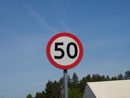 Traffic sign for speed limit 50 kilometers per hour against blue skyの写真素材