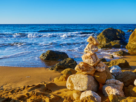 Pile of stones on the beach at Ramala Bay, Maltaの写真素材