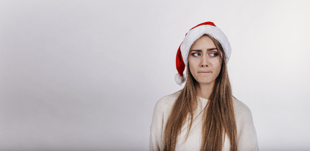 Pretty young model with blonde long hair, wide eyebrows and blue eyes posing on camera in studio on white background. Isolated. Copy space. Place for advertising.の写真素材