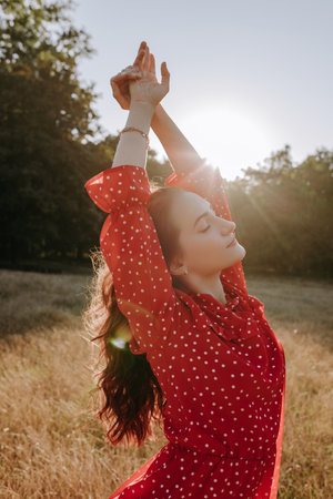 Redhead woman posing on a camera outdoor on the dry grass field on the forest backgroundの写真素材