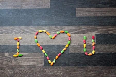 I Heart U made out of colorful rice on a gray kitchen counter to