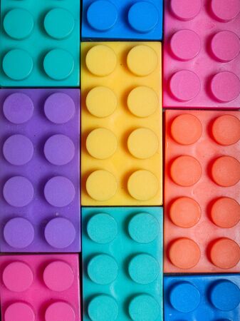 Multiple colored plastic building blocks on a gray background