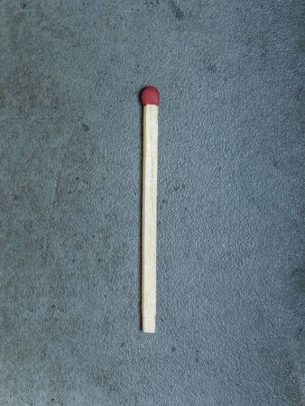 Single matchstick centered on a gray backgroundの写真素材