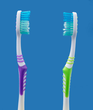 Couple concept with two toothbrushes facing each other on blue background. Minimal idea.