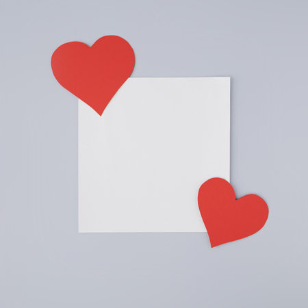Simple heart Valentine's Day card stock idea with red hearts on white paper and muted blue color backgroundの写真素材