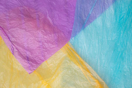 Purple, blue and orange plastic bags background for recycling idea. Minimal concept.
