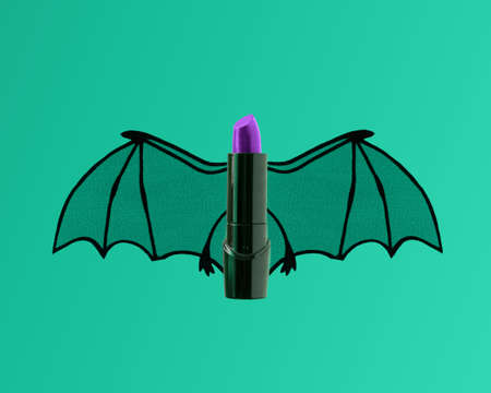 Blank black and purple lipstick tube with flying bat wings. Fun makeup beauty Halloween concept mockup.の写真素材