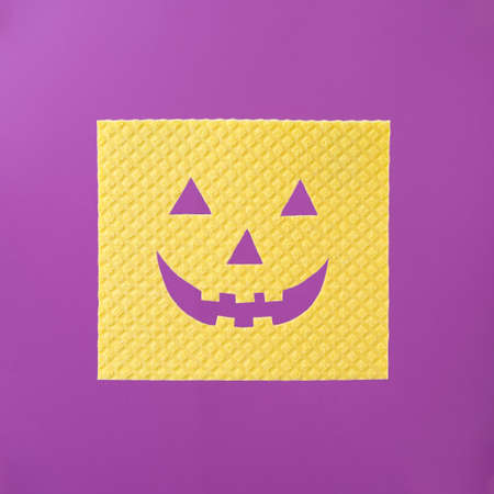 Yellow sponge with happy pumpkin face for Halloween cleaning household ideaの写真素材