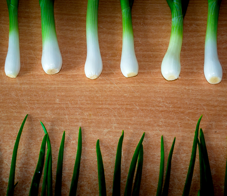 young onion leaves on a wooden backgroundの写真素材