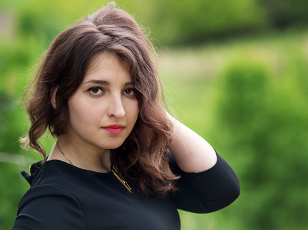 Beautiful girl with curly hair and red lipstick on the lipsの写真素材