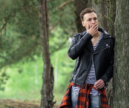 The guy in the leather jacket smoking in the woodsの写真素材