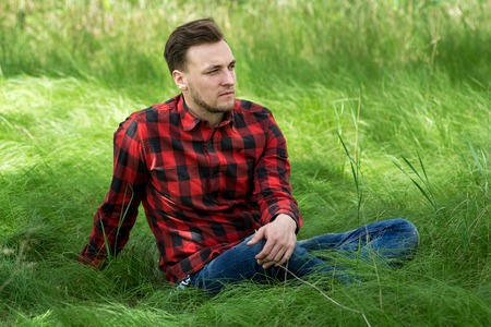 Trendy guy resting on the grassの写真素材