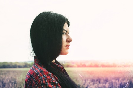 Girl in a field enjoying the beautiful sunset sunの写真素材