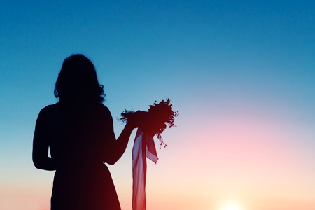 Silhouette of a bride holding a bouquet in lonelinessの写真素材