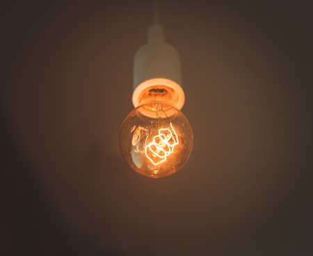 Old electric lightbulb in darknessの写真素材