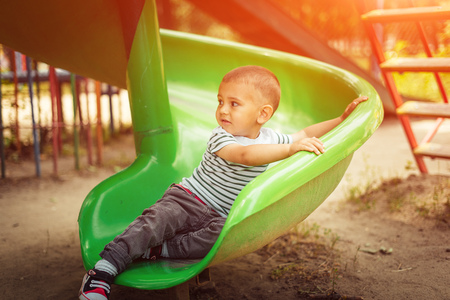happy little boy climbing on children playgroundの写真素材