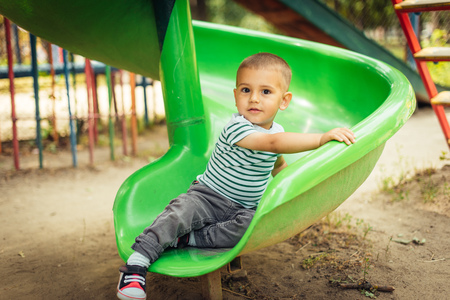 happy little boy climbing on children playgroundの写真素材