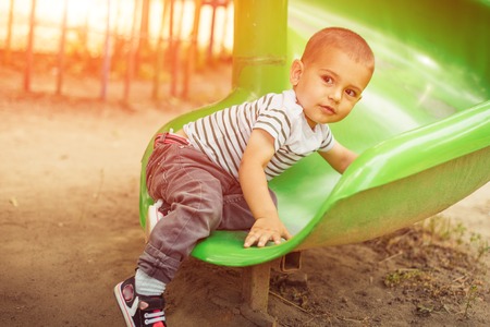 happy little boy climbing on children playgroundの写真素材
