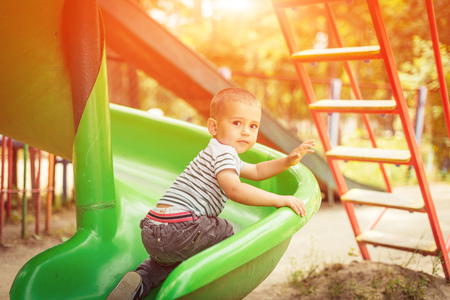 happy little boy climbing on children playgroundの写真素材