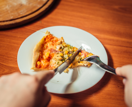 Hot pizza on a white plate. Pizza and cutlery