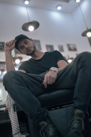 Man is sitting in a barbers chair barber shop.の写真素材