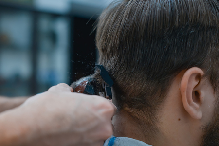 Men's haircut in barbershop. Barber shears clippers. Close up. Soft focus.の写真素材