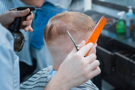 The Barber is cutting a man with scissors. Close up.の写真素材