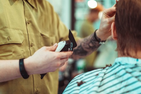 Men's haircut in barbershop. Hair care. Tinted photo. Soft focus.
