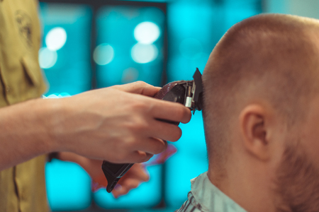 Men's beauty salon. Haircut closeup. Tinted photo. Soft focus.の写真素材