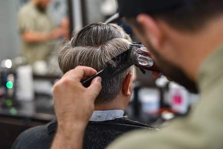 Men's haircut in barbershop. Hair Care. Barber cuts the client.の写真素材