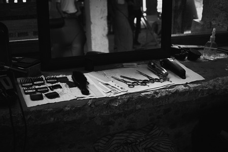 The tools of a Barber on the desktop in front of the mirror .Black and white photo of hairdresser...