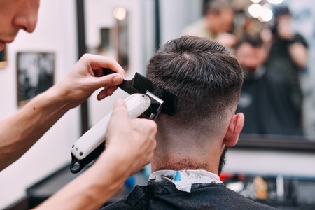 A man is hanging around in a beauty salon. Haircut and styling in barbershop. Men's care for beard and hair.の写真素材