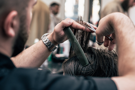 A man is hanging around in a beauty salon. Haircut and styling in barbershop. Men's care for beard and hair.の写真素材