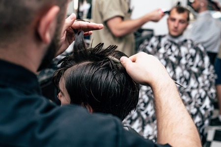 A man is hanging around in a beauty salon. Haircut and styling in barbershop. Men's care for beard and hair.の写真素材
