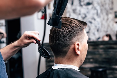 Barber in Barbershop shear hair electric car to young guy hipper for fashionable hairstyle.の写真素材