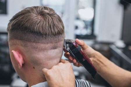 Haircut men Barbershop. Men's Hairdressers barbers. Barber cuts the client machine for haircuts.の写真素材