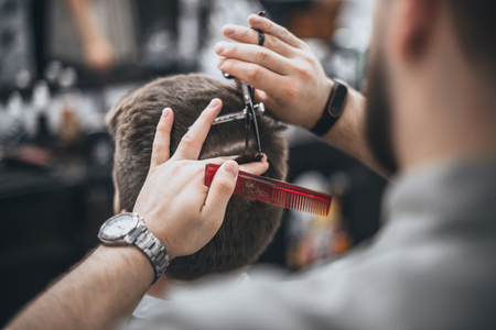 Hair Care. Barber makes a haircut with scissors. Soft focus.の写真素材