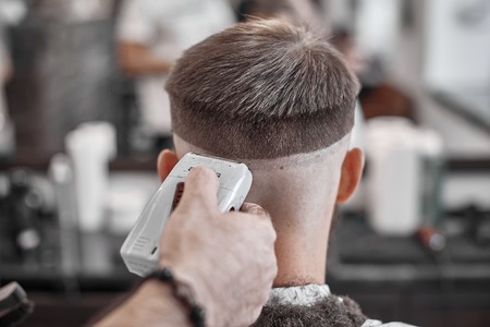 Haircut and hair styling in barbershop. Hair Care. Men's style and lifestyle. Barber brings a haircut and beard to his client.の写真素材