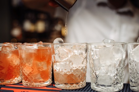 Glasses with ice. The barman is preparing strong alcoholic beverages.