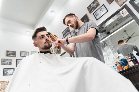 Haircut and beard haircut in barbershop. Man haircutの写真素材